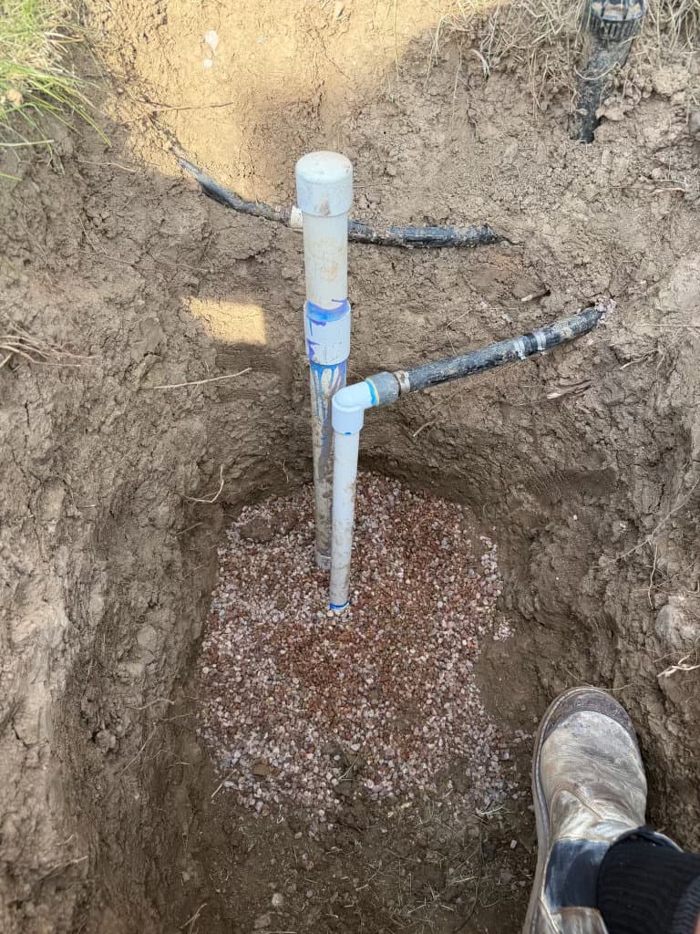 During: new PVC sewer cleanout with crushed-rock bed in excavated yard — Northern Colorado sewer cleanout installation