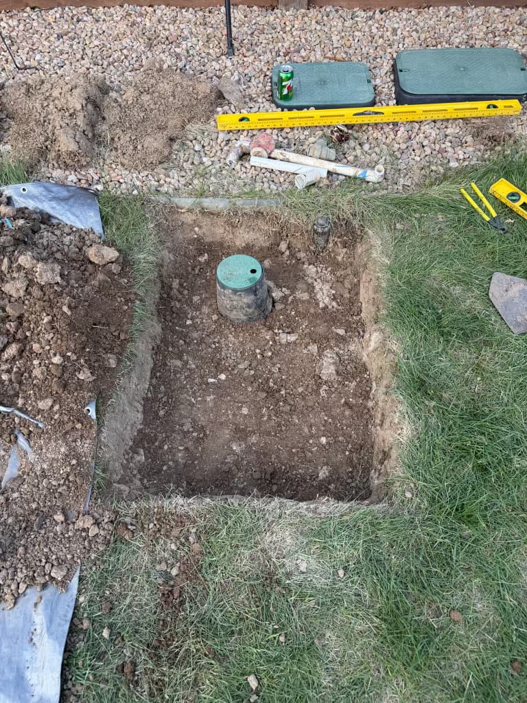 During: sewer cleanout excavation with green access cap set in place — Oopsie Daisy Plumbing Northern Colorado