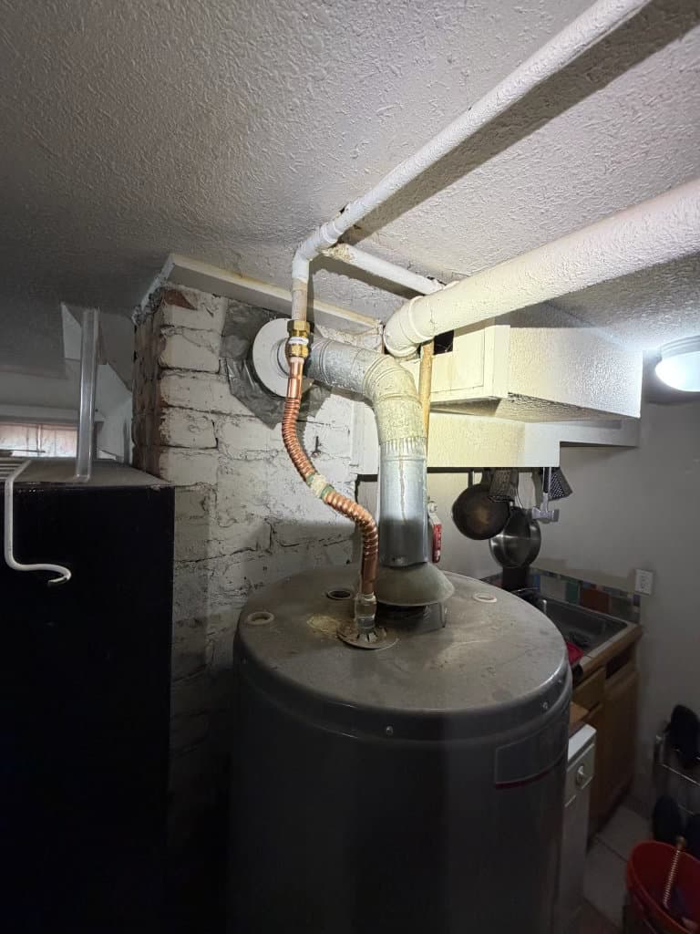 Before: water heater with aging galvanized fittings and corroded flex connector — Oopsie Daisy Plumbing Northern Colorado